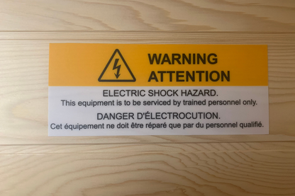 Warning label on a wooden surface indicating electric shock hazard.