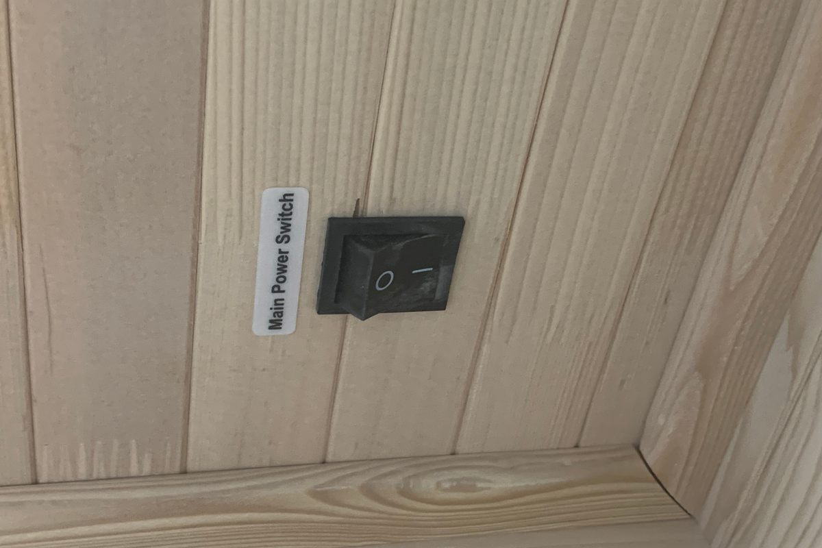 Main power switch on a wooden panel with a label