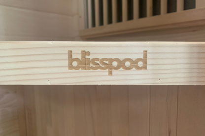 Wooden structure with 'blisspod' branding on a blurred background