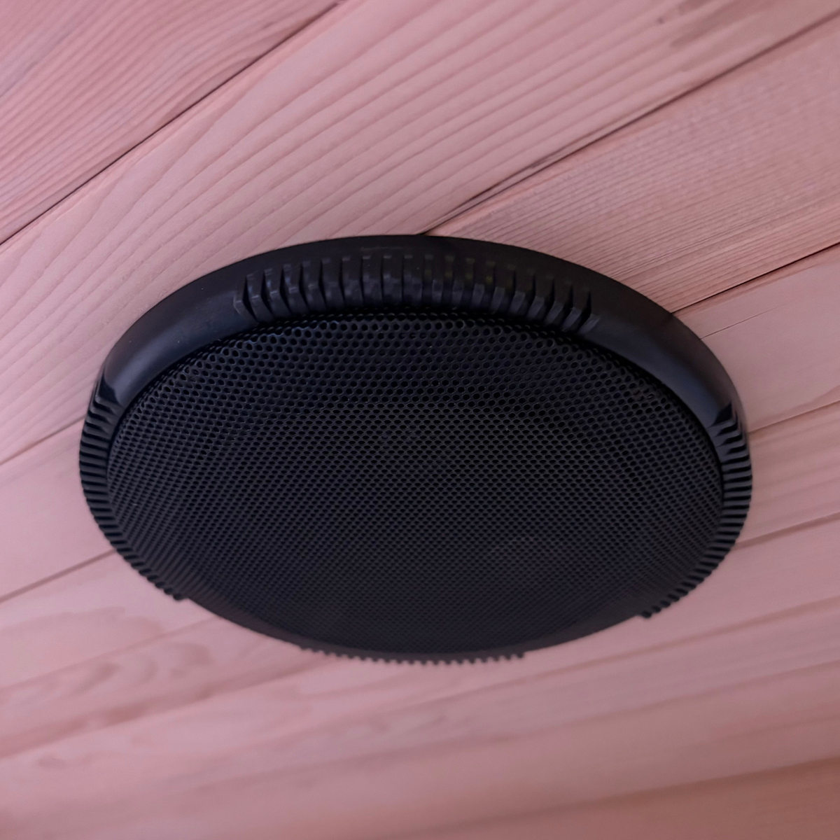 Black round speaker grille on a wooden surface