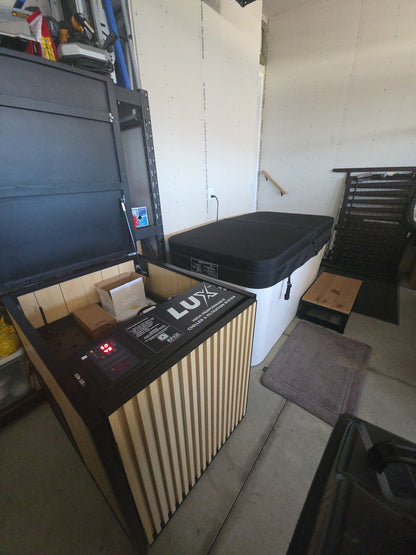 A luxury outdoor hot tub and matching wood-paneled control console in a garage setting.