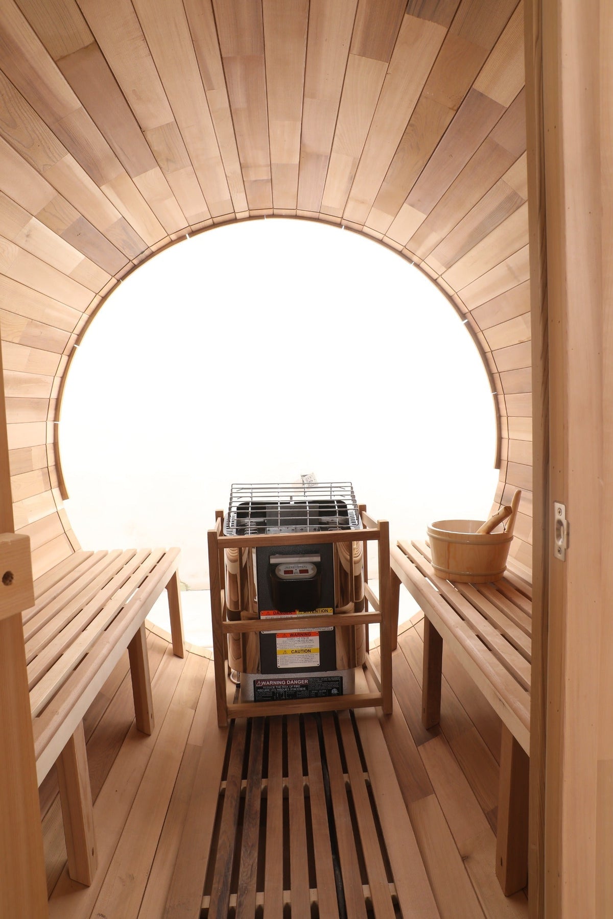 Wooden sauna interior with benches and a central shelf.