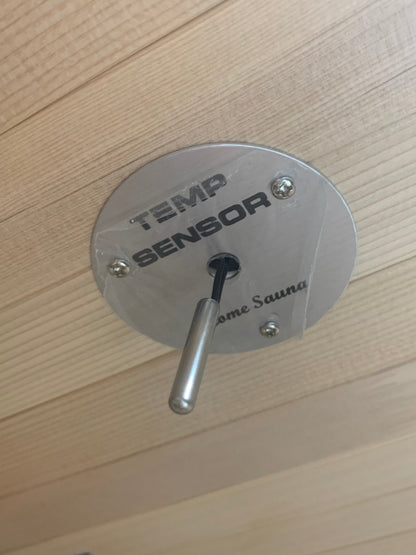 Metallic temperature sensor on a wooden surface